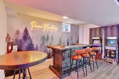 a bar in a restaurant with stools and a table at Chalet with Hot Tub, Game, Movie Room, Lake and Pool Access in Gouldsboro
