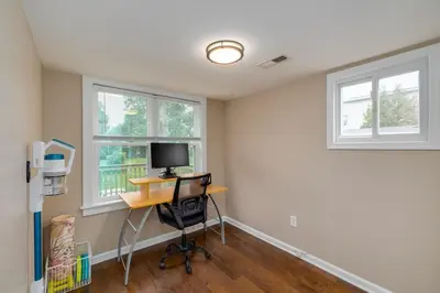 an empty room with a desk and two windows at Cozy Full Home with Parking, 10min Walk to Bridge St in Phoenixville