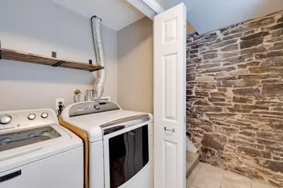 a kitchen with a stove and a brick wall at Cozy Full Home with Parking, 10min Walk to Bridge St in Phoenixville