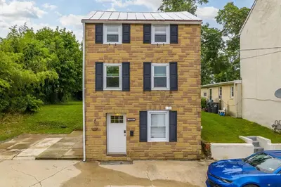 a brick house with a blue car in front of it at Cozy Full Home with Parking, 10min Walk to Bridge St in Phoenixville
