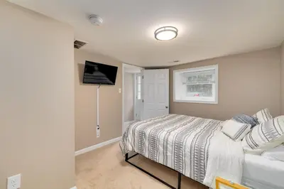 a bedroom with a bed and a tv on the wall at Cozy Full Home with Parking, 10min Walk to Bridge St in Phoenixville