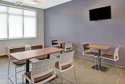 a conference room with tables and chairs and a flat screen tv at Microtel Inn & Suites by Wyndham Philadelphia Airport Ridley Park in Ridley Park