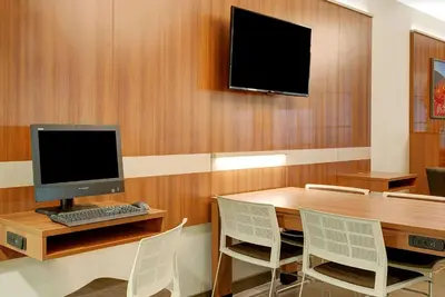 a room with a desk with a computer and chairs at Microtel Inn & Suites by Wyndham Philadelphia Airport Ridley Park in Ridley Park