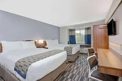 a hotel room with two beds and a television at Microtel Inn & Suites by Wyndham Philadelphia Airport Ridley Park in Ridley Park