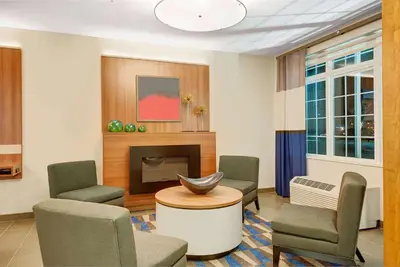 a waiting room with chairs and a fireplace at Microtel Inn & Suites by Wyndham Philadelphia Airport Ridley Park in Ridley Park