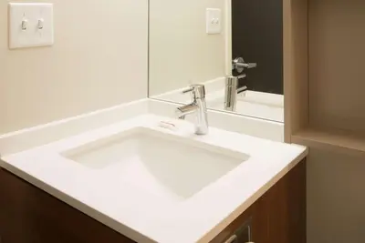 a bathroom with a white sink and a mirror at Microtel Inn & Suites by Wyndham Philadelphia Airport Ridley Park in Ridley Park