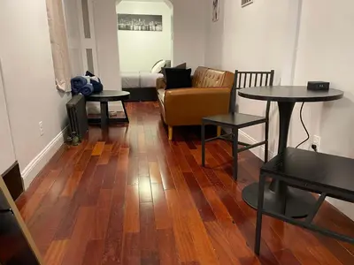 a living room with wood floors and a couch and tables at Private Studio Apartment in Union Square in New York
