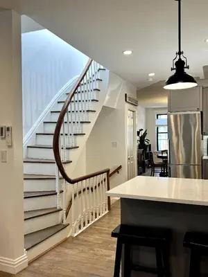 a staircase in a home with a kitchen and a table at Luxury duplex - 10 min to NYC/Times Square in Hoboken