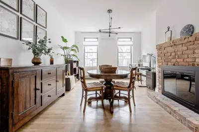 a dining room with a table and a fireplace at Luxury duplex - 10 min to NYC/Times Square in Hoboken