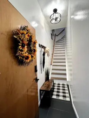 a hallway with a wreath on a door and stairs at Luxury duplex - 10 min to NYC/Times Square in Hoboken