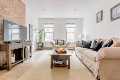 a living room with a couch and a tv at Luxury duplex - 10 min to NYC/Times Square in Hoboken