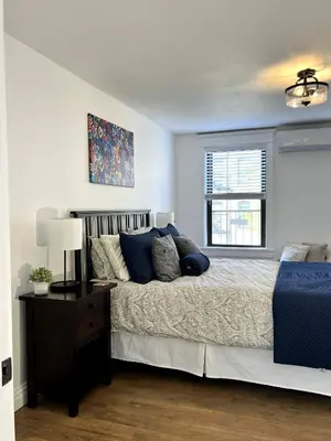 a bedroom with a large bed and a window at Luxury duplex - 10 min to NYC/Times Square in Hoboken
