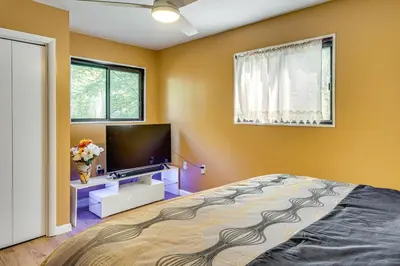 a bedroom with a bed and a flat screen tv at Poconos Family Home with Game Room and Community Perks in East Stroudsburg