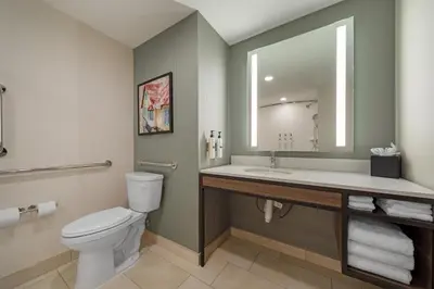 a bathroom with a toilet and a sink and a mirror at Hilton Garden Inn Media in Media