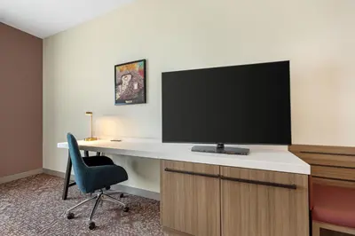a room with a desk with a tv and a chair at Hilton Garden Inn Media in Media