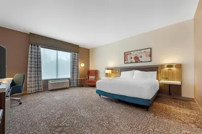 a hotel room with a bed and a desk and a window at Hilton Garden Inn Media in Media