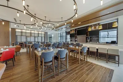 a restaurant with tables and chairs and a bar at Hilton Garden Inn Media in Media