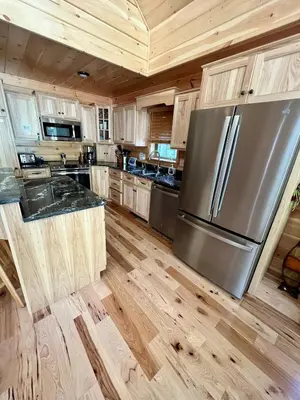 a kitchen with a stainless steel refrigerator and wooden cabinets at Luxury Cabin with Outdoor HotTub-NEW Construction in Lake Ariel