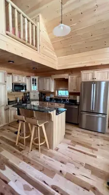a large kitchen with wooden ceilings and a large island at Luxury Cabin with Outdoor HotTub-NEW Construction in Lake Ariel
