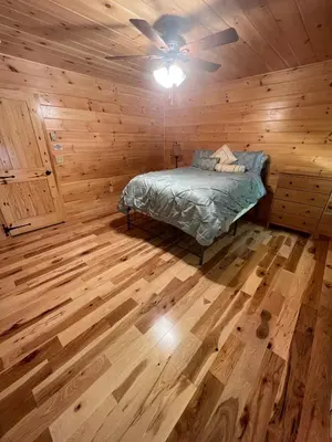 a bedroom with a bed and a ceiling fan at Luxury Cabin with Outdoor HotTub-NEW Construction in Lake Ariel