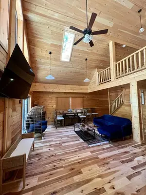 a living room with wooden floors and a ceiling fan at Luxury Cabin with Outdoor HotTub-NEW Construction in Lake Ariel