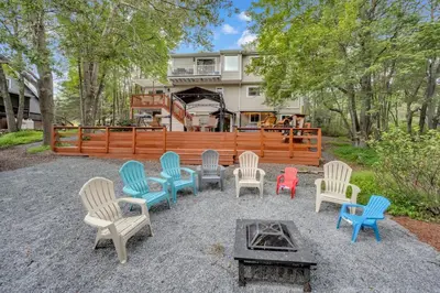a group of chairs and a table in front of a house at Stunning! Pocono Escape! HotTub Sauna Pool Ski Pet-Friendly Firepit Game Room Fireplace BBQ Lakes Tennis Fishing in Long Pond
