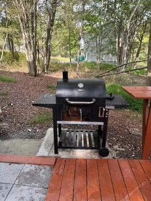 a grill sitting on a picnic table in a park at Stunning! Pocono Escape! HotTub Sauna Pool Ski Pet-Friendly Firepit Game Room Fireplace BBQ Lakes Tennis Fishing in Long Pond