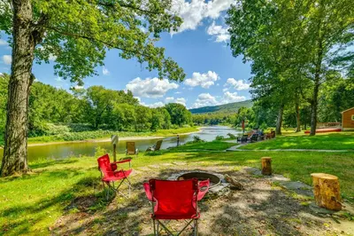 a group of red chairs sitting next to a river at 25 Mi to Elk Mtn Skiing! Susquehanna River Cabin