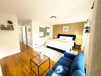 a living room with a blue couch and a bed at Luxury 3BR 2BA Retreat NYC Getaway Free Parking in Jersey City