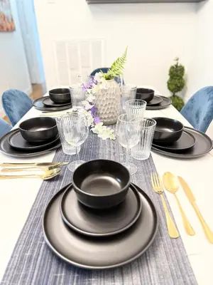 a table with black plates and glasses on it at Luxury 3BR 2BA Retreat NYC Getaway Free Parking in Jersey City