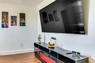 a living room with a flat screen tv on a wall at Walkable Location Pet-Friendly Apartment in Lodi! in Lodi