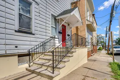 a home with a red door and stairs on a building at Walkable Location Pet-Friendly Apartment in Lodi! in Lodi