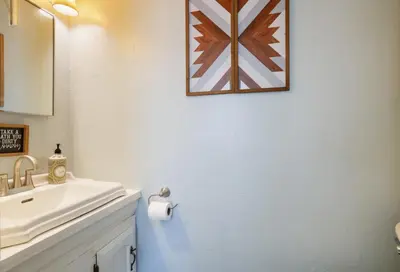 a bathroom with a sink and a picture on the wall at Spacious Broadway Home Downtown Western Modern Charm with parking in Jim Thorpe