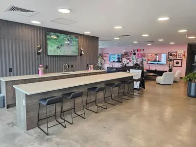 a kitchen with a bar with stools and a sink at Chic 1BR Old City Apt with King Bed, City View, and Gym in Philadelphia