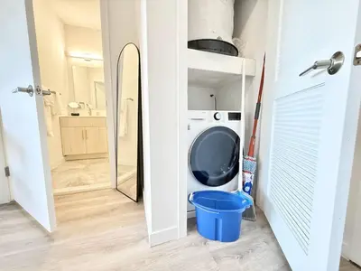 a laundry room with a washing machine and a mirror at Chic 1BR Old City Apt with King Bed, City View, and Gym in Philadelphia