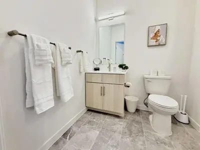 a white bathroom with a toilet and a sink at Studio Apt with City View, Rooftop and Gym in Philadelphia