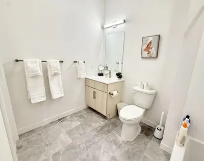 a white bathroom with a toilet and a sink at Studio Apt with City View, Rooftop and Gym in Philadelphia