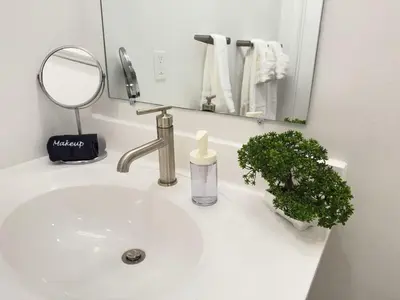 a bathroom sink with a mirror and a bottle of soap at Studio Apt with City View, Rooftop and Gym in Philadelphia
