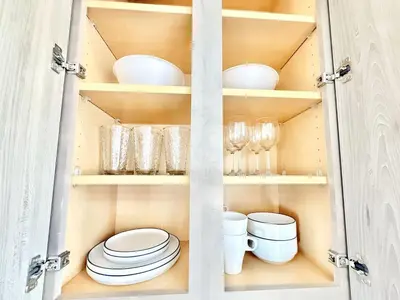 a cupboard with plates and bowls and glasses in it at Studio Apt with City View, Rooftop and Gym in Philadelphia