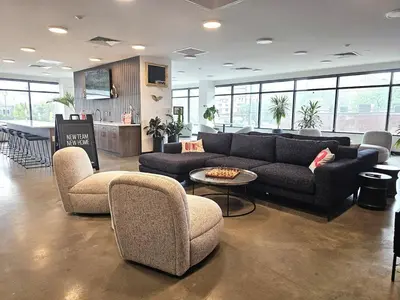 a living room with a couch and chairs and a kitchen at Studio Apt with City View, Rooftop and Gym in Philadelphia