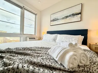 a bedroom with a bed with a large window at Boutique Studio with Rooftop View and Gym in Philadelphia