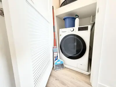 a washing machine in a closet with a broom at Boutique Studio with Rooftop View and Gym in Philadelphia