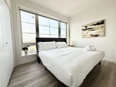 a bedroom with a large white bed in front of a window at 2 BR in the heart of an old city in Philadelphia