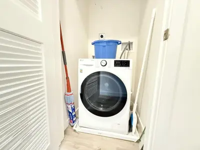 a washing machine in a closet with a mop at 2 BR in the heart of an old city in Philadelphia