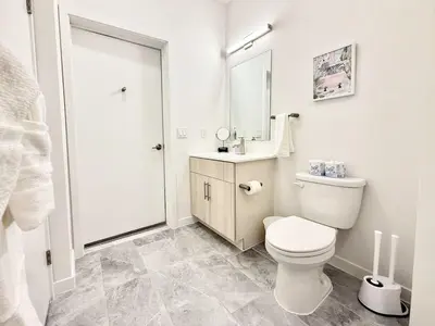 a white bathroom with a toilet and a sink at Central Philly 1Br Apt with Gym in Philadelphia