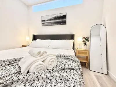a bedroom with a bed with a blanket and a mirror at Central Philly 1Br Apt with Gym in Philadelphia