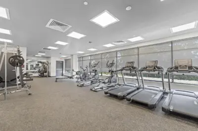 a gym with rows of treadmills and machines at Studio Apt with Skyline Views, King Bed, and Gym in Philadelphia