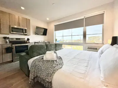 a bedroom with a large white bed and a couch at Studio Apt with Skyline Views, King Bed, and Gym in Philadelphia