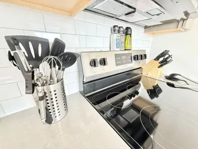 a kitchen counter with a stove and some utensils at Studio Apt with Skyline Views, King Bed, and Gym in Philadelphia