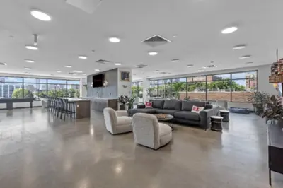 a large living room with couches and a bar at Studio Apt with Skyline Views, King Bed, and Gym in Philadelphia